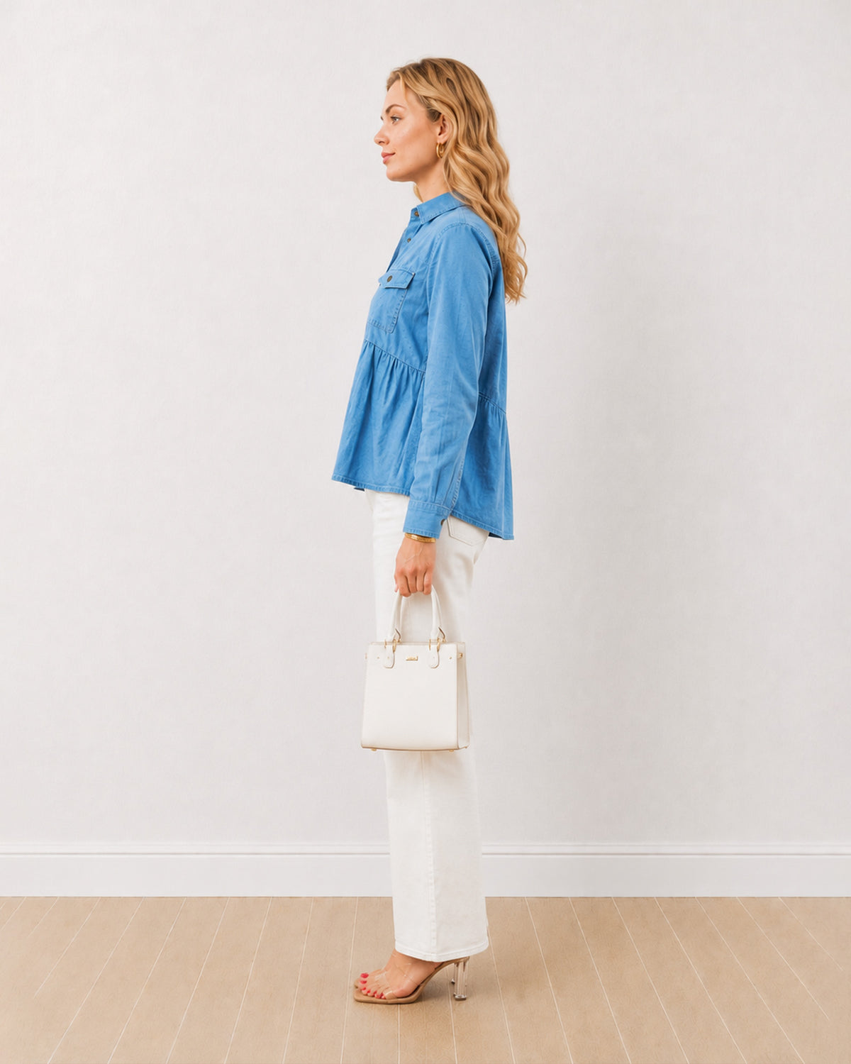 Delta light blue denim peplum shirt, side profile view with gathers at the waist