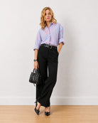 Gazillion Diane black formal trousers for women, full length front view with hand in the side cross pocket