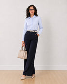 Diane navy blue formal trousers, front view turned with hand in the side cross pocket