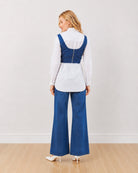 Donna indigo denim corset over white shirt, back view showing the corset back zipper