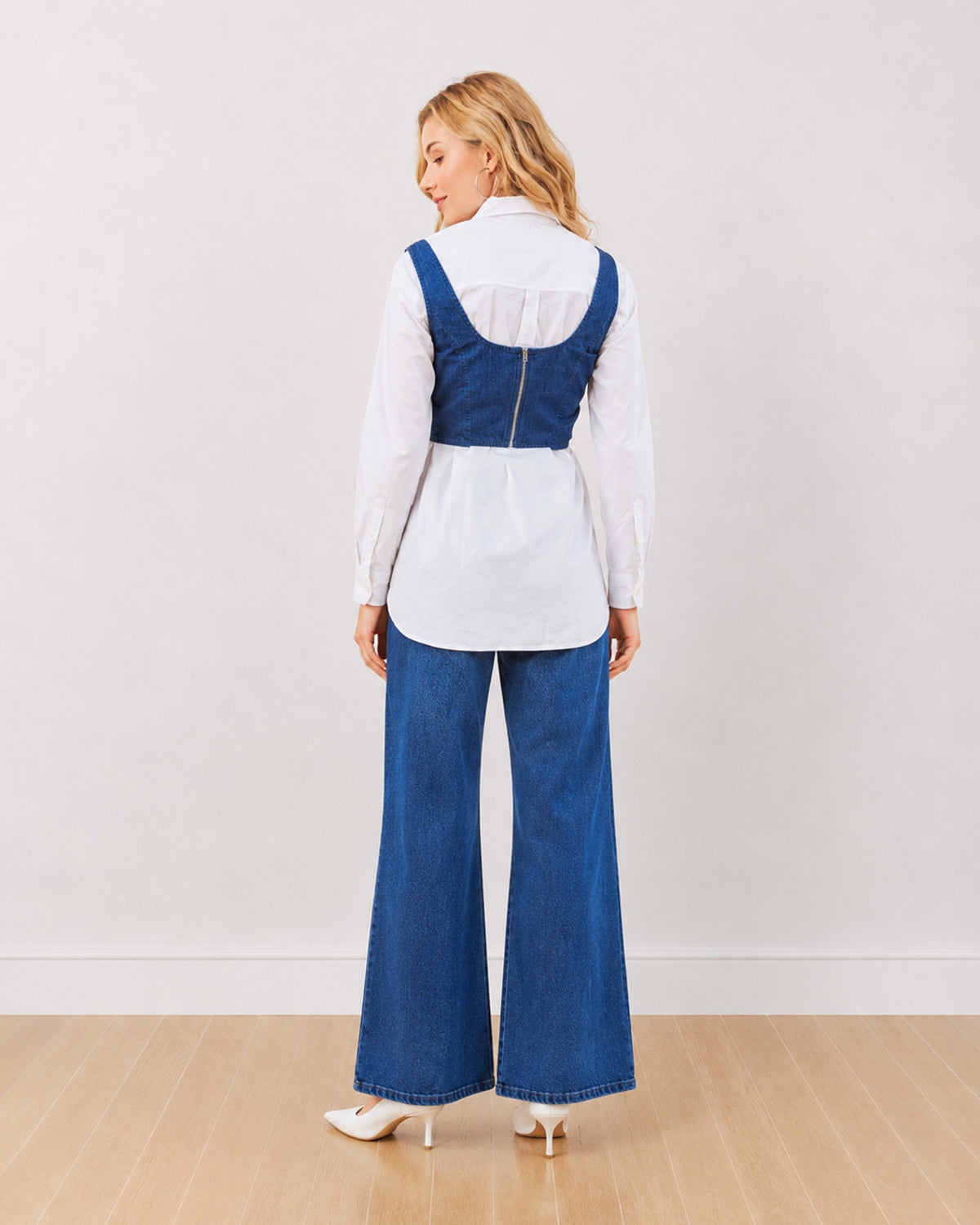 Donna indigo denim corset over white shirt, back view showing the corset back zipper
