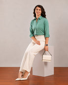Dora emerald green formal shirt, seated angled view with rolled sleeves