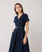 Flora denim fit-and-flare dress, angled view showing the belted waist
