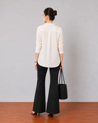 Gemini beige linen tunic top, back view showing shoulder pleats and a curved split hem