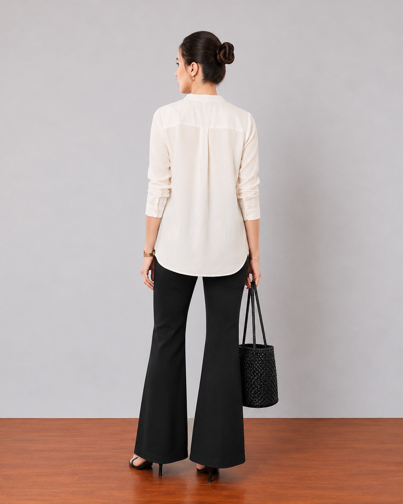 Gemini beige linen tunic top, back view showing shoulder pleats and a curved split hem