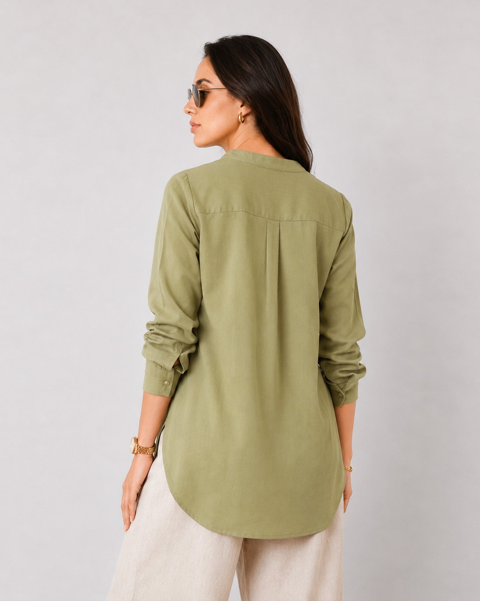 Gemini moss green linen tunic top turned to show the back yoke pleat and curved split hem