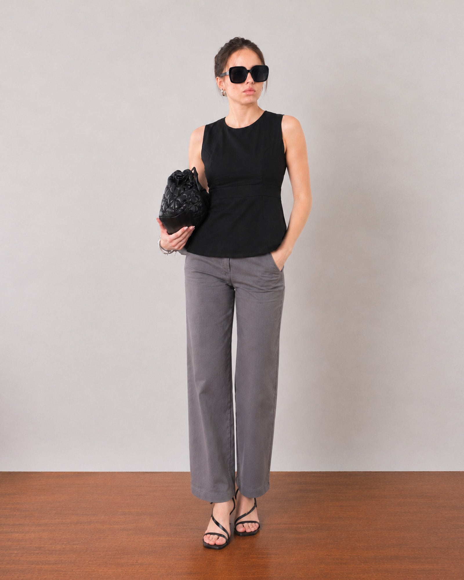 Gianna black sleeveless linen top with subtle panel detailing, angled front view