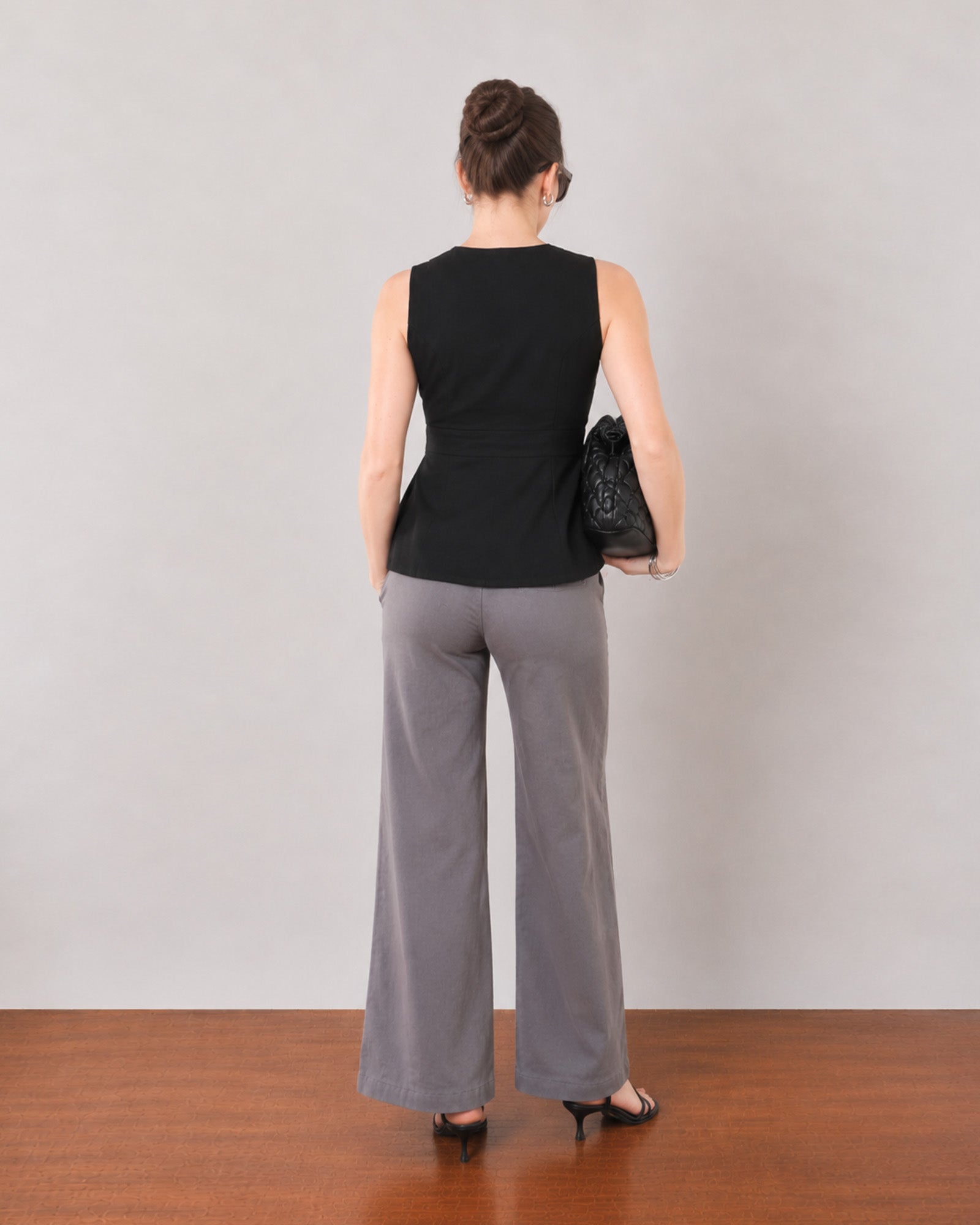 Gianna black linen top, back view showing panel seams and a softly flared hem