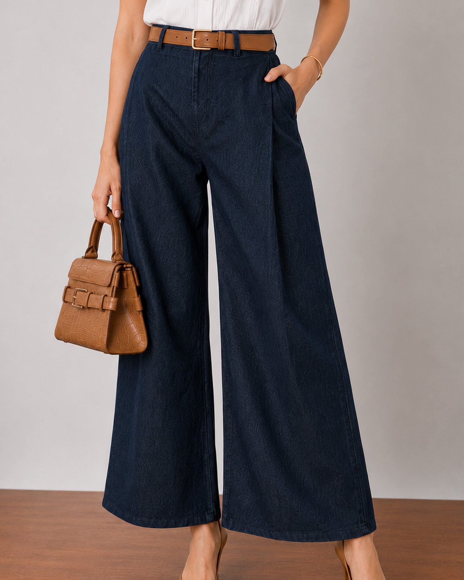 Close-up of Gigi indigo blue denim pants waistband and double front pleats