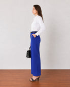 Glin royal blue cotton satin pants with structured front pleats, side profile showing the broad leg drape