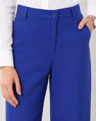 Close-up of Glin royal blue cotton pants waistband, belt loops, button fly and structured front pleat