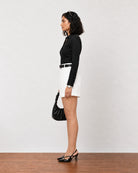 Grace white lyocell linen shorts with a cuffed hem, side view showing the relaxed drape