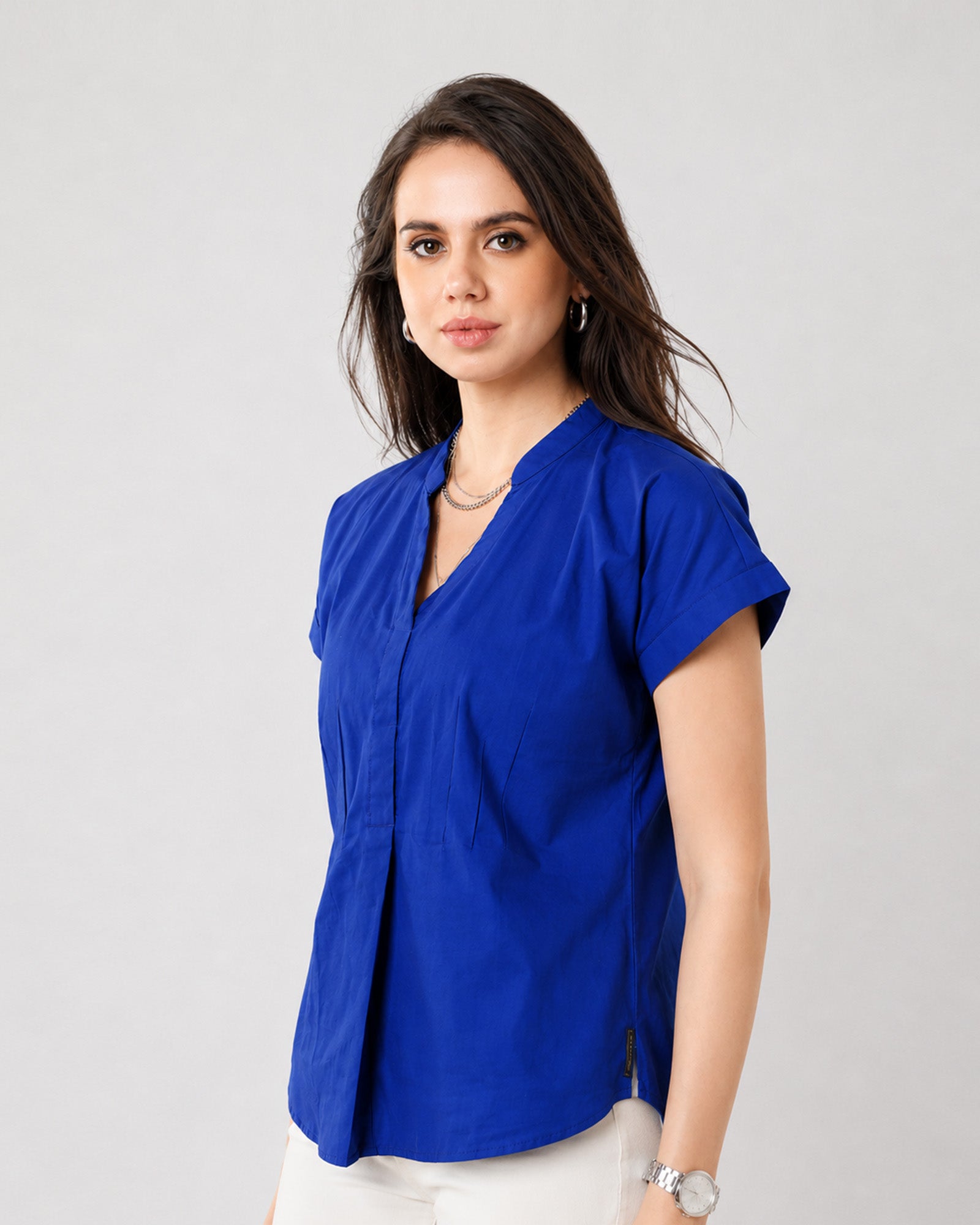 Greta royal blue cotton satin top with neat folded cuff sleeves, close-up view
