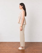 Gretchen beige printed peplum top with a flared peplum fall, side profile view