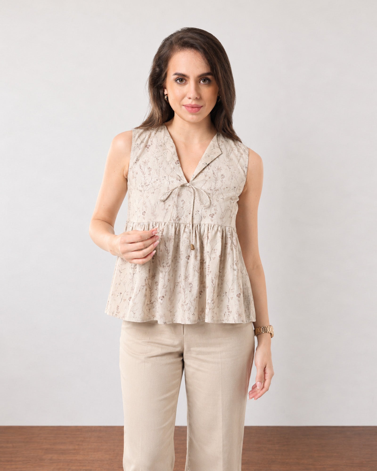 Close-up of Gretchen beige peplum top tie-front neckline with a subtle V-opening