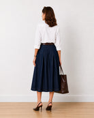 Hansel indigo blue denim midi skirt, back view with concealed side zipper and clean pleats