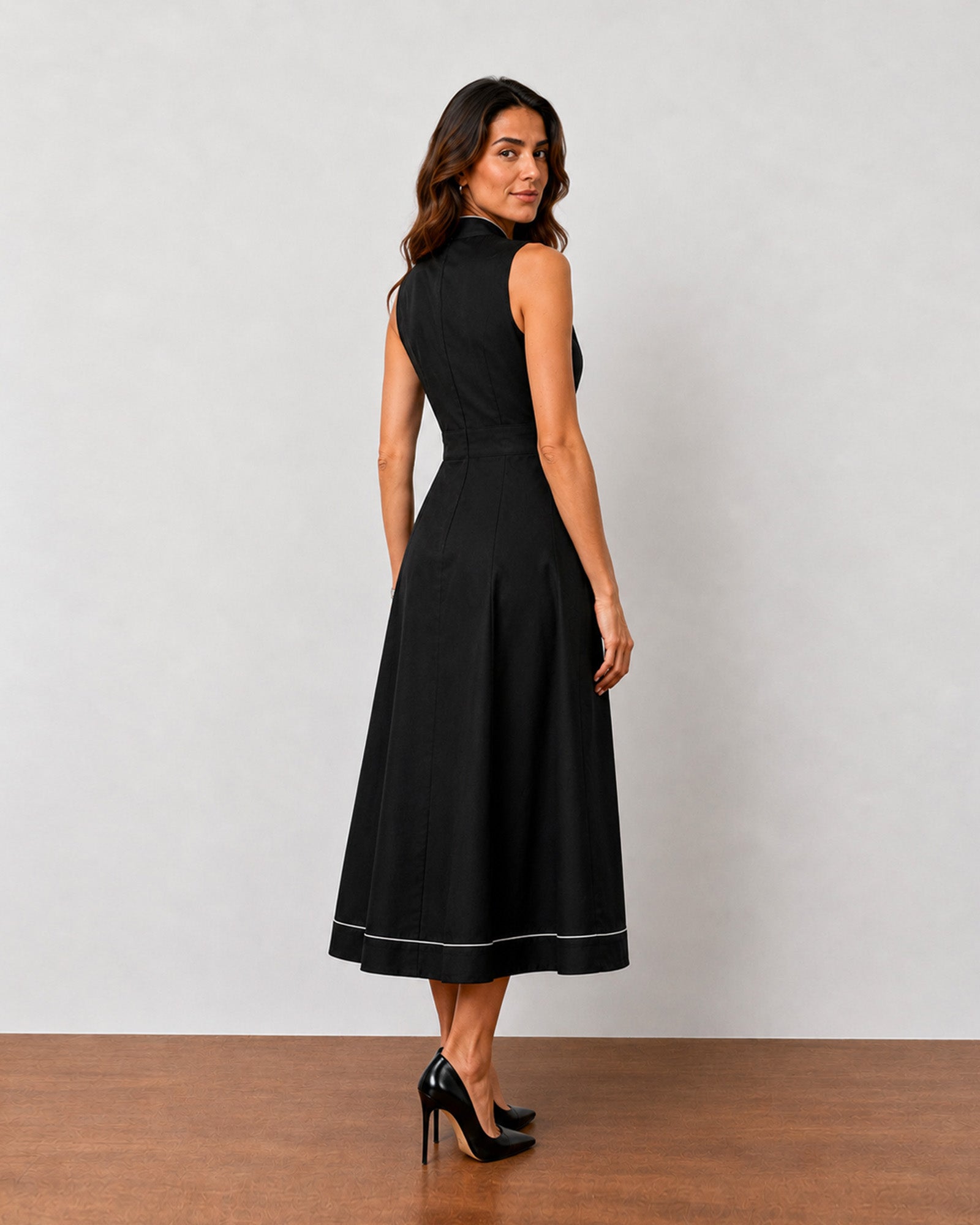 Hectoria black cotton midi dress, back view showing flared below-knee skirt and seams