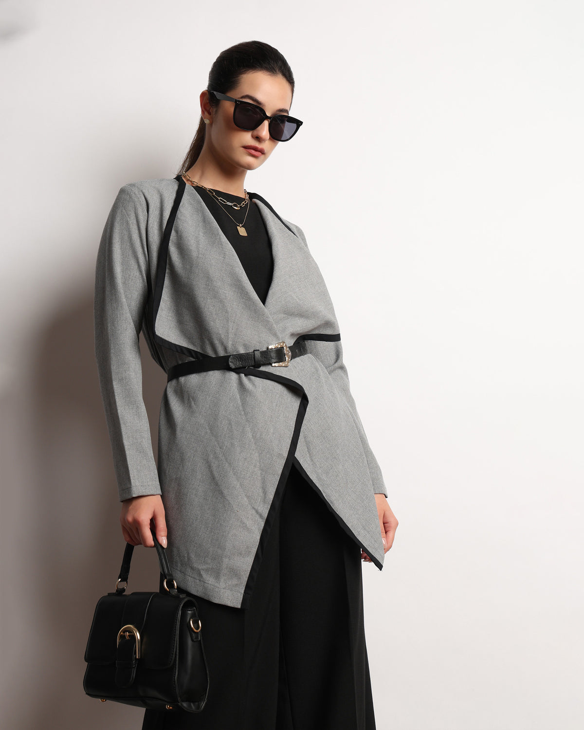 Hermina dark grey drapy cape top worn belted and styled with a shoulder bag, front view