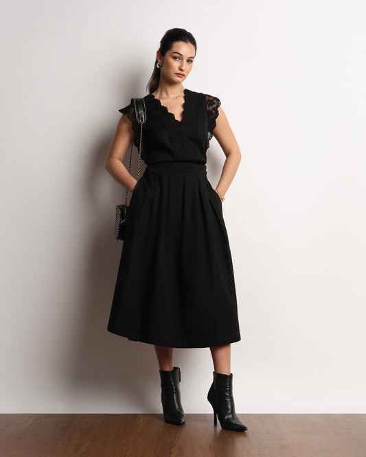 Hertha black lace V neck top worn with a hand in the pocket, full-length front view