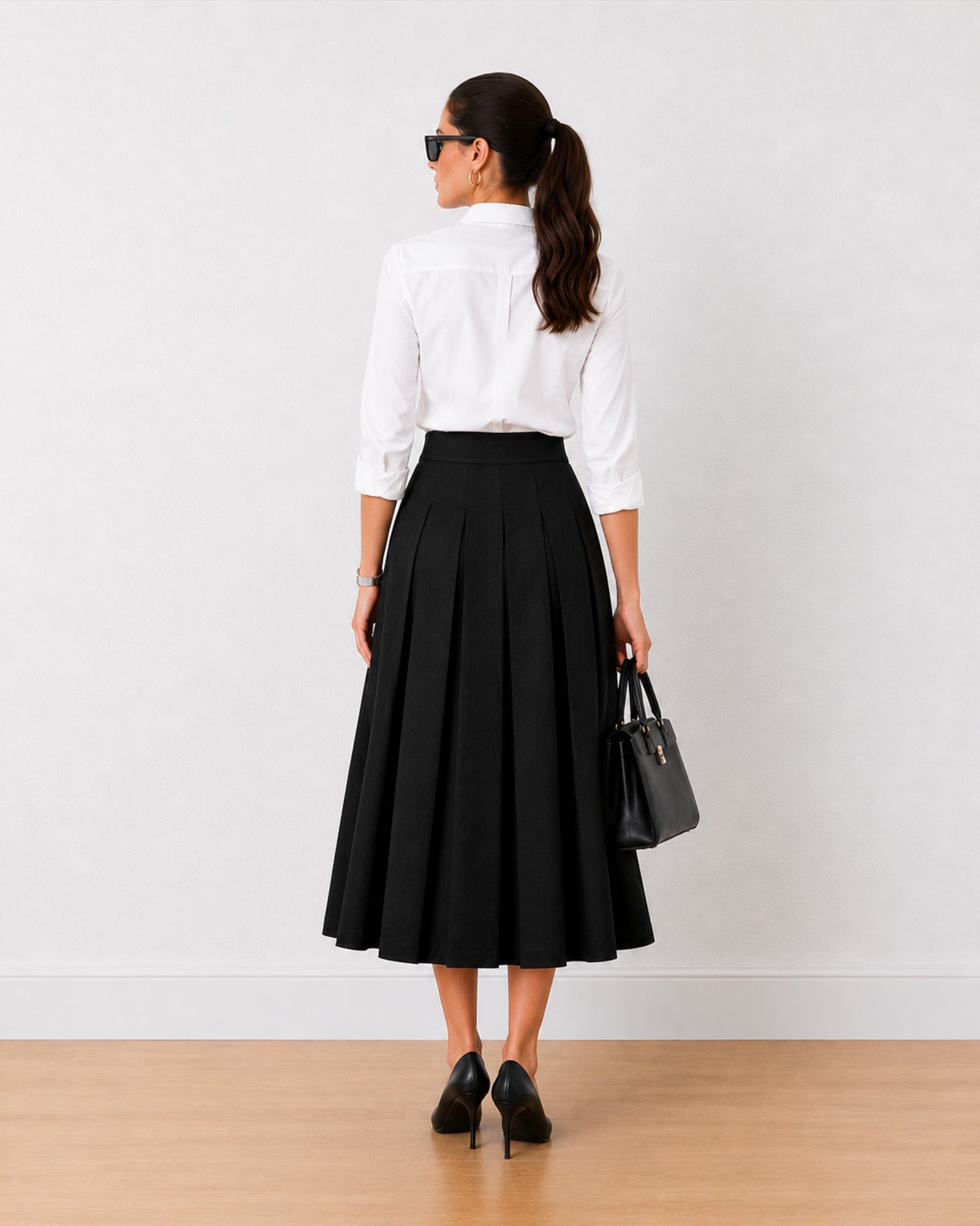 Hester black cotton midi skirt, back view showing concealed side zipper and pleats