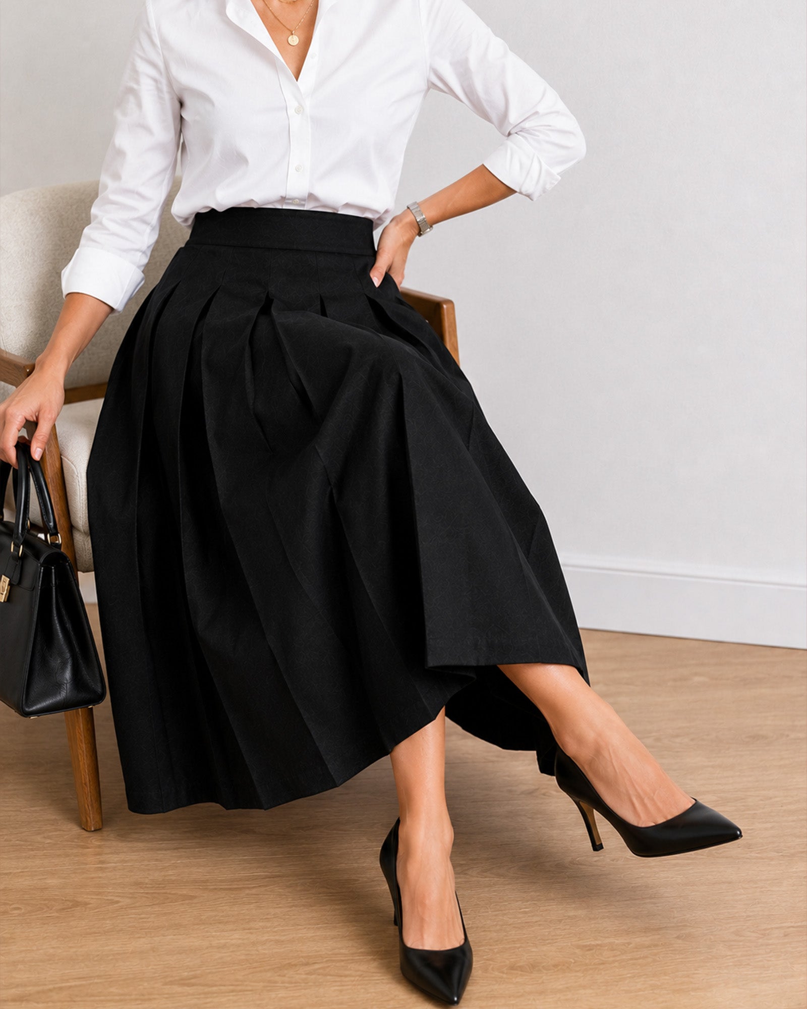 Hester black pleated cotton skirt, seated view showing full A-line drape