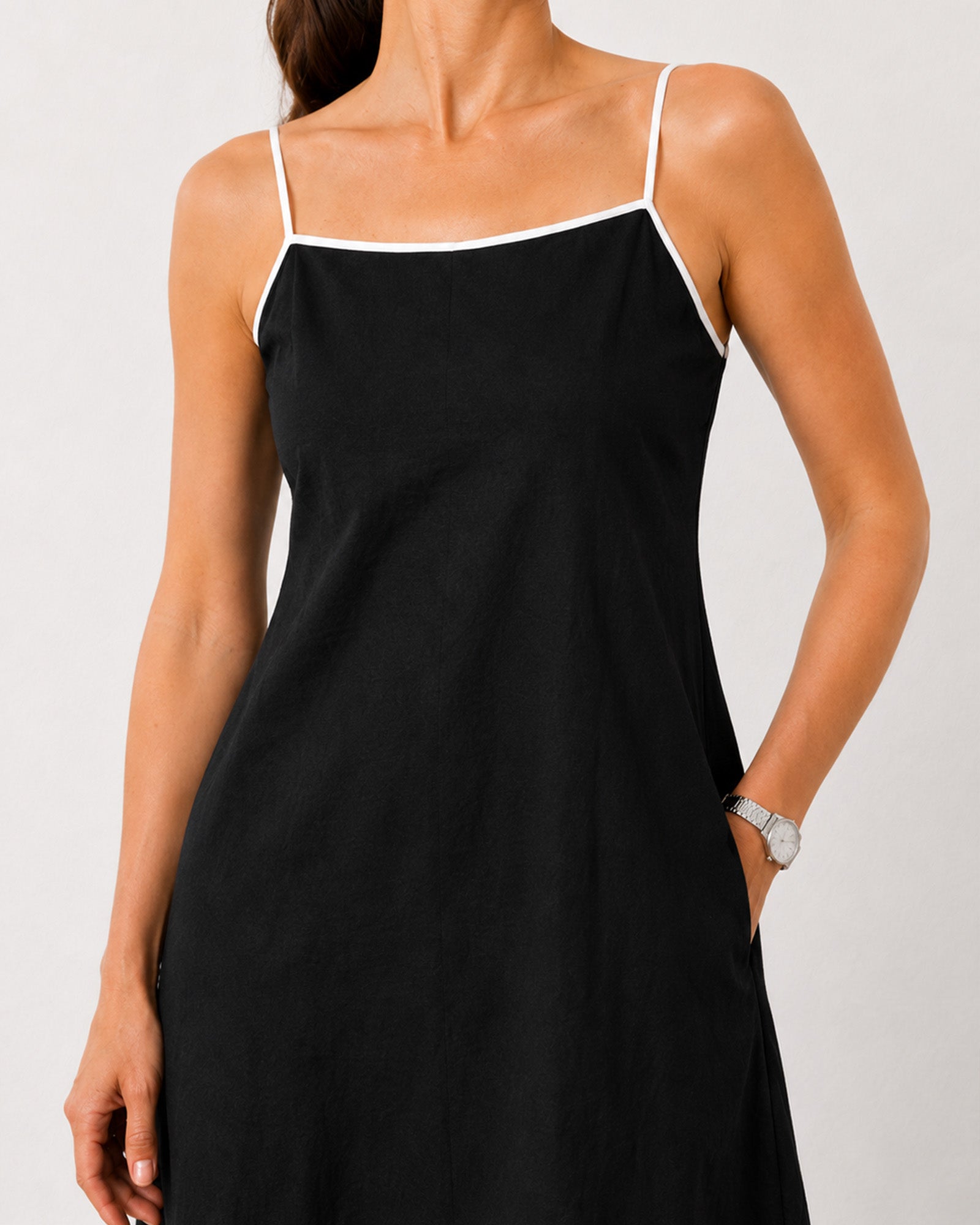 Close-up of Holiday black linen maxi dress noodle straps and contrast piped neckline